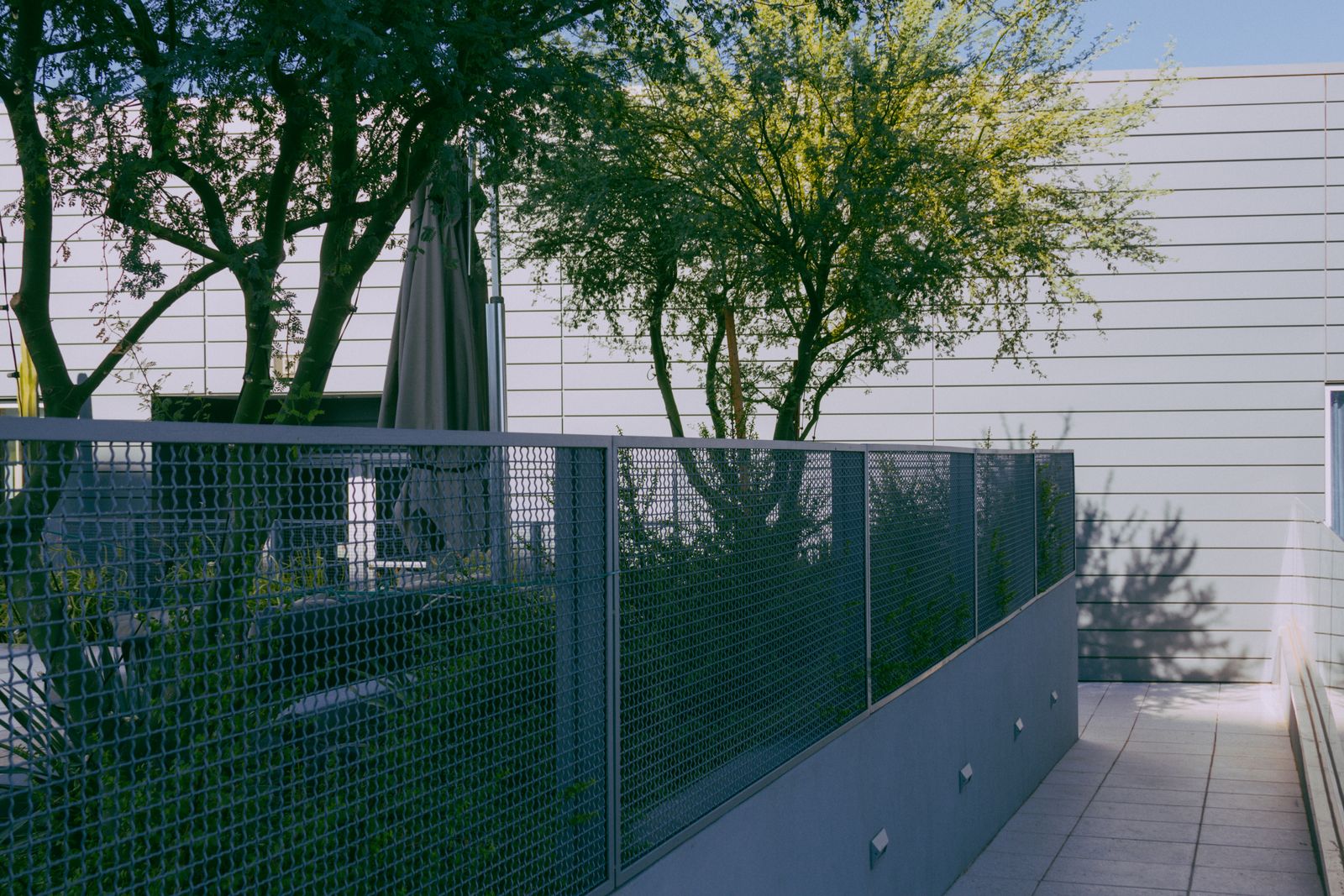 Modern steel fence panel installed alongside a contemporary building